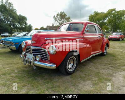 Chascomus, Argentinien - 9. Apr 2022: Der alte rote Chevrolet Chevy Stylesmaster 1948 Coupé von General Motors parkte auf dem Land. Naturrasen Stockfoto