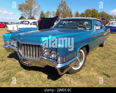 Chascomus, Argentinien - Apr 9, 2022 - Altblauer Luxus Cadillac DeVille Limousine viertürig 1970 auf dem Rasen geparkt. Oldtimer-Show. Copyspace Stockfoto