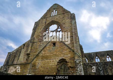 Ein Blick auf die leeren Fensterrahmen aus Buntglas an einem trüben, launischen Nachmittag. Bei Tintern Abby in der Nähe von Chepstow, Wales, Großbritannien. Stockfoto