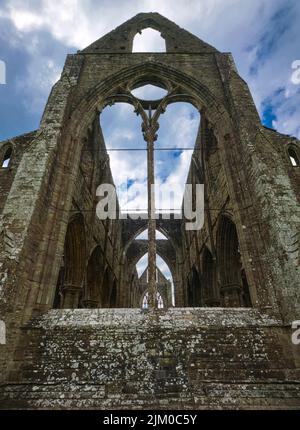 Ein Blick auf die leeren Fensterrahmen aus Buntglas an einem trüben, launischen Nachmittag. Bei Tintern Abby in der Nähe von Chepstow, Wales, Großbritannien. Stockfoto