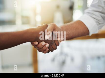 Ein Team-Handschlag in Abstimmung zwischen Kollegen und Kollegen in einem Büro. Zusammenarbeit als Team, um Erfolg zu erzielen, als Partnerschaft zu verschmelzen oder Stockfoto