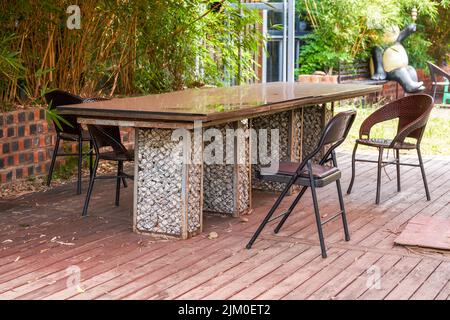Kopfsteinpflaster-Tisch mit langen Beinen im Garten Stockfoto