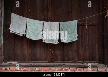 Handtücher an einem Seil außerhalb eines Hauses aufhängen Stockfoto