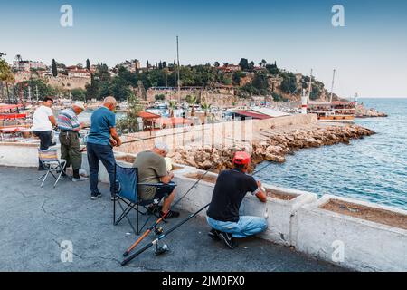 21. Juni 2022, Antalya, Türkei: Fischer mit Angelruten entspannen sich am Pier in der Nähe des Hafens der Altstadt von Antalya Stockfoto