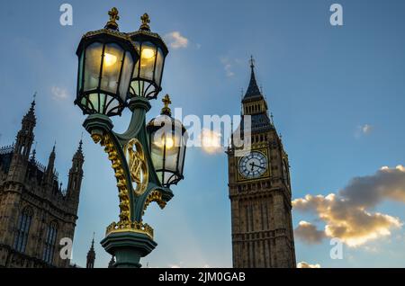 Wunderschöne Straßenbeleuchtung über dem Hintergrund des berühmten Big Ben unter einem blauen, bewölkten Himmel, London Stockfoto