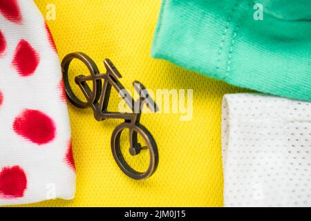 Eine Nahaufnahme eines kleinen Fahrradstifts auf einem gelben, grünen und weißen T-Shirt für eine Tour de France Stockfoto