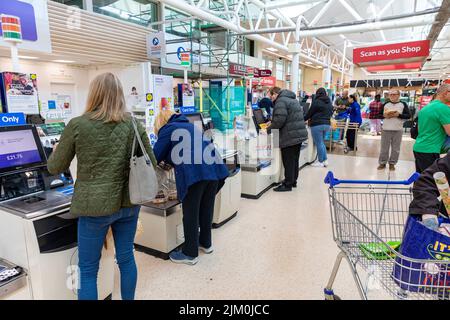 Tesco Supermarkt, Kunden mit Selbstbedienungsautomaten, um für ihre Lebensmittel zu bezahlen, Tesco bietet auch Scan-as-you-Shop-Service, Manchester, Großbritannien Stockfoto