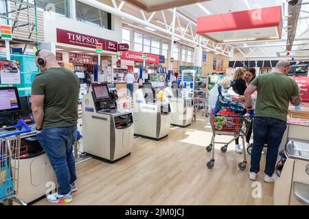 Tesco Supermarkt, Kunden mit Selbstbedienungsautomaten, um für ihre Lebensmittel zu bezahlen, Tesco bietet auch Scan-as-you-Shop-Service, Manchester, Großbritannien Stockfoto