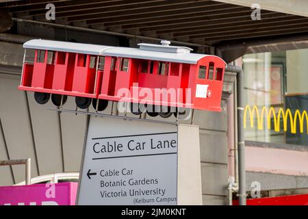 Bunte Straßenschilder mit Symbolen und Informationen in Wellington City, darunter die Buzzy Bee, der Zug und die Seilbahn Stockfoto