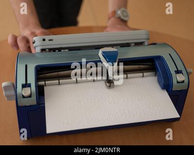 Blinder Mann mit Brailleschrift-Schreibmaschine. Stockfoto