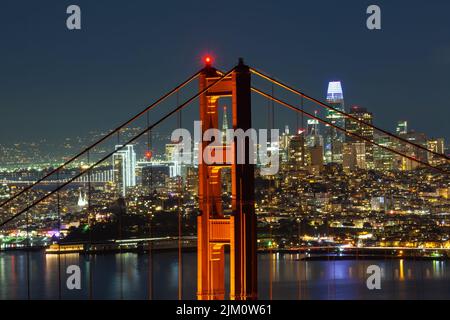 Eine Luftaufnahme der Golden Gate Bridge und der beleuchteten Skyline von San Francisco bei Nacht Stockfoto