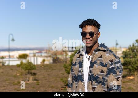 Porträt eines lächelnden Mannes, der im Sommer eine Sonnenbrille im Freien trägt Stockfoto