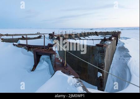 Ölbohrkessel, Boden wurde im Winter in Thetis Bay, vor der Küste von Herschel Island in der kanadischen Beaufort-See, nahe der Küste gegründet Stockfoto