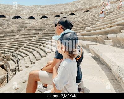 Der junge Vater Vater und sein Schuljunge Sohn Touristen besuchen alte antike kolosseum Amphitheater Ruinen an heißen Sommertagen Stockfoto