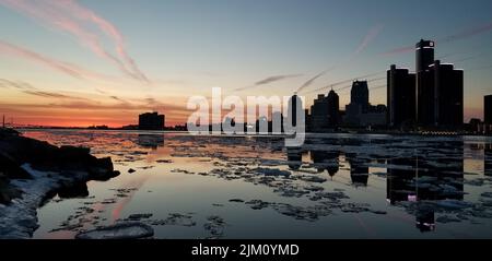 Eine malerische Aussicht auf eine gefrorene Meereslandschaft, die den Sonnenuntergang vor dem Stadtbild von Detroit, Michigan, widerspiegelt Stockfoto