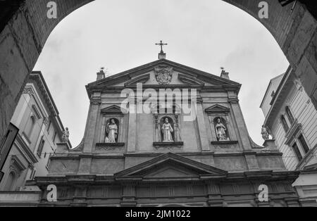 Eine Graustufenaufnahme der Fassade der Kirche San Benedetto gegen den bewölkten Himmel in Bologna, Italien Stockfoto