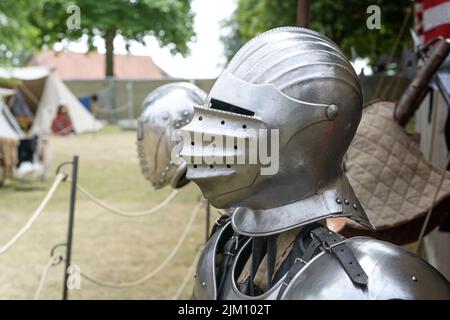 Ritter Helm aus Metall mit Visier nach unten, Replik auf einem mittelalterlichen Lager mit historischen Rüstungen und Waffen, Kopierraum, ausgewählter Fokus, enge Tiefe des Fiels Stockfoto