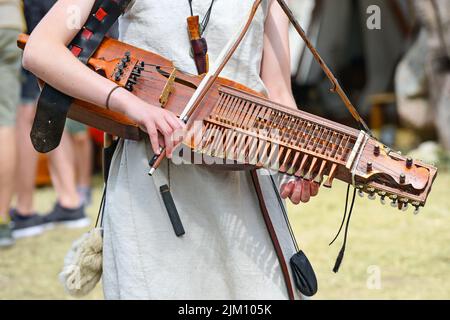 Nyckelharpa, keyed Fiddle, ein traditionelles schwedisches Musikinstrument, Streichinstrument oder Chordophon, gespielt von einer jungen Frau auf einem mittelalterlichen Fest, Stockfoto