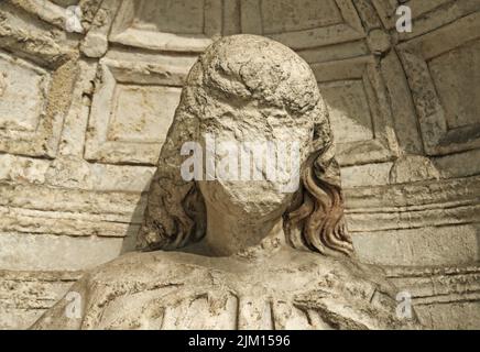 Ein Ststue mit beschädigtem Gesicht an der Außenseite einer Kirche Stockfoto