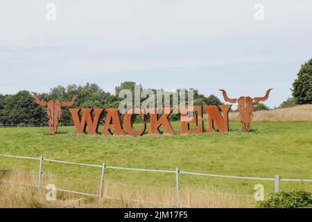 Wacken, Deutschland. 04. August 2022. Der Schriftzug des WOA - Wacken Open Air steht auf einer Wiese. Das WOA gilt als das größte Heavy Metal Festival der Welt. Quelle: Frank Molter/dpa/Alamy Live News Stockfoto