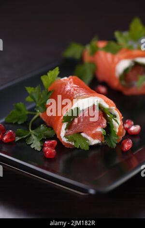 Lachsstreifen mit Frischkäse und Grapefruit, aufgerollt. Diese mundgerechte Runde ist eine großartige Option, um als Aperitif, ein perfektes fes, zu dienen Stockfoto