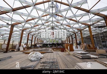 München, Deutschland. 04. August 2022. Arbeiter bauen auf dem Oktoberfest ein Festzelt. Auf einer Pressekonferenz am 04.08.2022 sollen die Innovationen auf dem Oktoberfest 2022 vorgestellt werden. Das Oktoberfest findet in diesem Jahr von 17.09.2022 bis 03.10.2022 statt. Quelle: Sven Hoppe/dpa/Alamy Live News Stockfoto