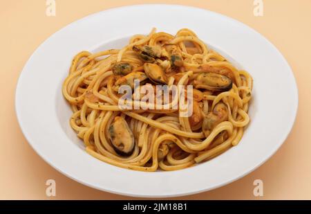 Italienische Spaghetti mit Muscheln und Tomatensuppe isoliert auf klarem Hintergrund Stockfoto