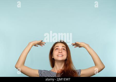 Lächelndes Mädchen halten über Kopf Hände Werbung Stockfoto