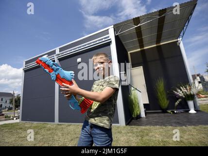 Nicht exklusiv: MAKARIV, UKRAINE - 1. AUGUST 2022 - Ivan Kyrylenko, 8, gehört zur Familie, die die Besitzer des ersten modularen Hauses wurde un gebaut Stockfoto