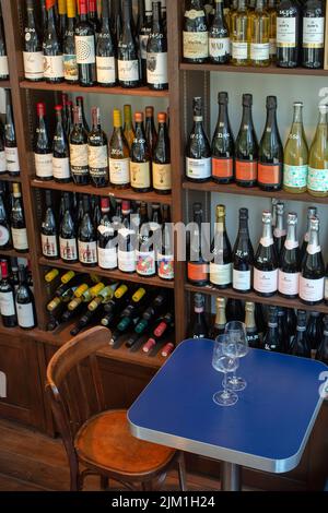 Blick auf Weinglas mit Flaschen in Regalen in einem Weinladen Stockfoto