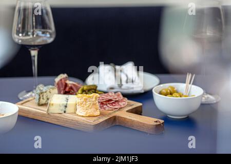 Rotwein mit Wurstplatte auf rustikalem Holz Stockfoto