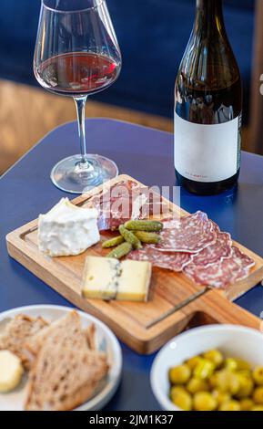 Rotwein mit Wurstplatte auf rustikalem Holz Stockfoto