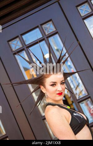 Blackpool, Lancashire, Großbritannien. 4. August 2022. Erin Micklow, Schauspielerin der amerikanischen sag-AFTRA, Stylistin der Garderobe, Moderator von YouTuber Influencer. Punk-Subkultur, Ideologien, Mode, mit Mohican gefärbten Frisuren und Farbstoffen beim Punk Rebellion Festival in den Winter Gardens. Ein Protest gegen konventionelle Einstellungen und Verhaltensweisen, ein Zusammenprall von Anti-Establishment-Kulturen, Mohawks, Sicherheitsnadeln und eine Menge Haltung in der Küstenstadt, da Punks, die das jährliche Rebellion Rock Music Festival in den Wintergärten besuchen, mit traditionellen Urlaubern Seite an Seite stehen. Stockfoto