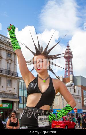 Blackpool, Lancashire, Großbritannien. 4. August 2022. Erin Micklow, Schauspielerin der amerikanischen sag-AFTRA, Stylistin der Garderobe, Moderator von YouTuber Influencer. Punk-Subkultur, Ideologien, Mode, mit Mohican gefärbten Frisuren und Farbstoffen beim Punk Rebellion Festival in den Winter Gardens. Ein Protest gegen konventionelle Einstellungen und Verhaltensweisen, ein Zusammenprall von Anti-Establishment-Kulturen, Mohawks, Sicherheitsnadeln und eine Menge Haltung in der Küstenstadt, da Punks, die das jährliche Rebellion Rock Music Festival in den Wintergärten besuchen, mit traditionellen Urlaubern Seite an Seite stehen. Stockfoto