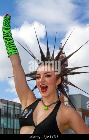 Blackpool, Lancashire, Großbritannien. 4. August 2022. Erin Micklow, Schauspielerin der amerikanischen sag-AFTRA, Stylistin der Garderobe, Moderator von YouTuber Influencer. Punk-Subkultur, Ideologien, Mode, mit Mohican gefärbten Frisuren und Farbstoffen beim Punk Rebellion Festival in den Winter Gardens. Ein Protest gegen konventionelle Einstellungen und Verhaltensweisen, ein Zusammenprall von Anti-Establishment-Kulturen, Mohawks, Sicherheitsnadeln und eine Menge Haltung in der Küstenstadt, da Punks, die das jährliche Rebellion Rock Music Festival in den Wintergärten besuchen, mit traditionellen Urlaubern Seite an Seite stehen. Stockfoto