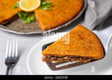 Traditionelles Essen von Antakya - Truthahn, Oruk im Tablett. (Türkischer Name; Tepside icli kofte, Tepside oruk, tepsi orugu, sini kofte) Hatay Oruk Essen. Stockfoto