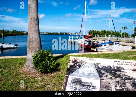 Hafenszene mit Booten, Pier, Docks und Fishermans Wharf im Hintergrund: Punta Gorda, Florida Charlotte County, entlang des Harborwalk Mehrzweckweges Stockfoto