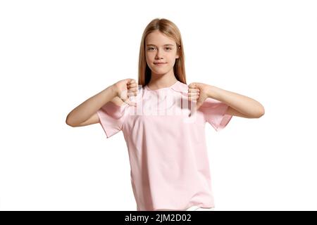 Studio-Porträt eines schönen Mädchen blonde Teenager in einem rosa T-Shirt posiert isoliert auf weißem Hintergrund. Stockfoto