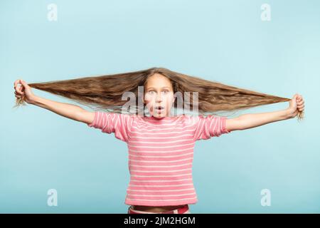 haircare Styling schockiert Mädchen halten lange wellige Haare Stockfoto
