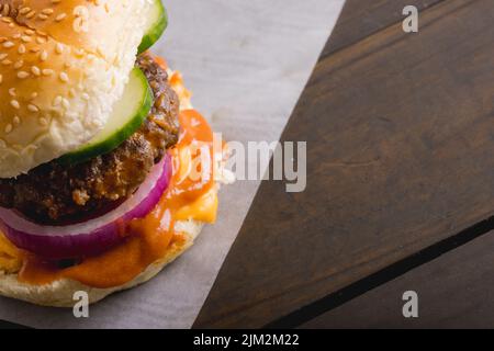 Nahaufnahme eines frischen Burgers aus dem hohen Winkel auf einem Holztisch, Platz zum Kopieren Stockfoto