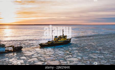 Eisbrecher geht auf dem Meer zwischen dem blauen Eis bei Sonnenuntergang, Luftaufnahme Stockfoto