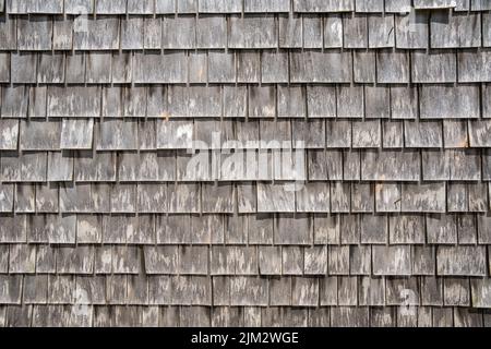 Nahaufnahme der grau verwitterten Schindeln auf einem typischen Cape Cod Gebäude. Stockfoto