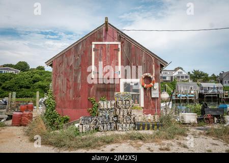 Menemsha, Martha's Vineyard, Massachusetts, USA-26. Juli 2022: Malerisches, rustikales, verwittertes, graues Schindelgebäude in einem berühmten Fischerdorf. Stockfoto