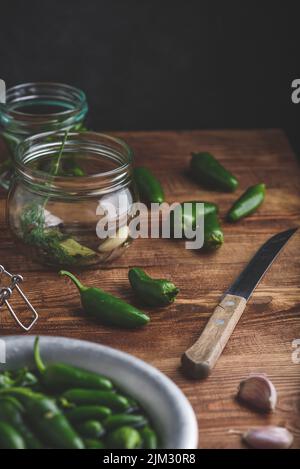 Jalapeno Peppers für Canning, Gewürze, Knoblauch und Glasbehälter auf Holztisch. Speicherplatz Kopieren Stockfoto