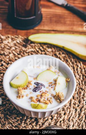 Hausgemachtes Müsli mit frischem Birnen und Milch in Vintage Bowl Stockfoto