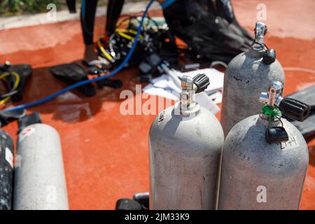 Nahaufnahme von Tauchbecken an einem tropischen Strand in Mexiko. Im Hintergrund das Karibische Meer. Tauchflaschen tanken. Stockfoto