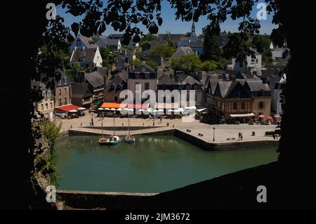 Restaurants und Straßencafés mit farbenfrohen Markisen und Sonnenschirmen säumen jetzt den Place Saint-Sauveur im Saint-Goustan-Viertel Auray, Morbihan, der südlichen Bretagne, Frankreich. Saint-Goustan, einst ein geschäftiges Fischerei- und Handelshafen, ist heute ein beliebtes Touristenziel, das einem Besuch des US-Gründervaters Benjamin Franklin im Jahr 1776 Tribut zollt. Stockfoto