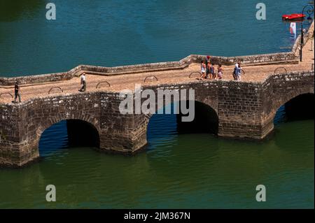 Sommerspazler auf der Pont Neuf, der alten Steinbrücke mit vier Bögen, die die oberen und unteren Stadtgebiete von Auray in Morbihan, der südlichen Bretagne, Frankreich, über den Fluss Loch oder Loc'h verbindet Eine Steinbrücke, die die Oberstadt am Nordwestufer mit dem Hafengebiet von Saint-Goustan am Südost-Ufer verbindet, wurde erstmals im Jahr 1200s aufgezeichnet. Es wurde zweimal umgebaut, in den Jahren 1464 und 1752. Stockfoto