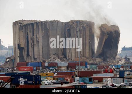 Beirut, Libanon. 04. August 2022. Ein großer Teil der Hafensilos in Beirut bricht zusammen, als die Libanesen den 2.. Jahrestag der massiven Explosion vom 4.. August 2020 feierten, die durch den Hafen riss, bei der mehr als 200 Menschen ihr Leben verloren. Im nördlichen Teil der Silos ist seit etwa drei Wochen ein Feuer verbrannt. Kredit: Stringer/dpa/Alamy Live Nachrichten Stockfoto