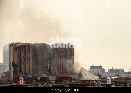 Beirut, Libanon. 04. August 2022. Ein großer Teil der Hafensilos in Beirut bricht zusammen, als die Libanesen den 2.. Jahrestag der massiven Explosion vom 4.. August 2020 feierten, die durch den Hafen riss, bei der mehr als 200 Menschen ihr Leben verloren. Im nördlichen Teil der Silos ist seit etwa drei Wochen ein Feuer verbrannt. Quelle: Marwan Naamani/dpa/Alamy Live News Stockfoto